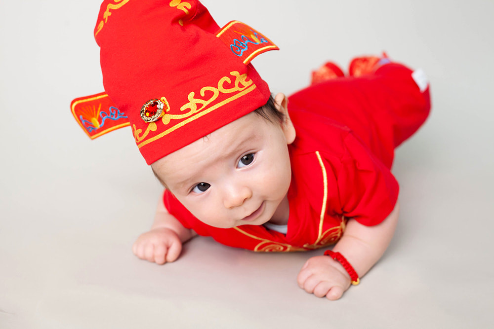 Cute 100 day old baby boy in traditional Chinese clothes