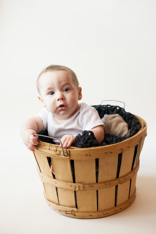 Baby boy in basket looks into camera in Wesley Chapel FL