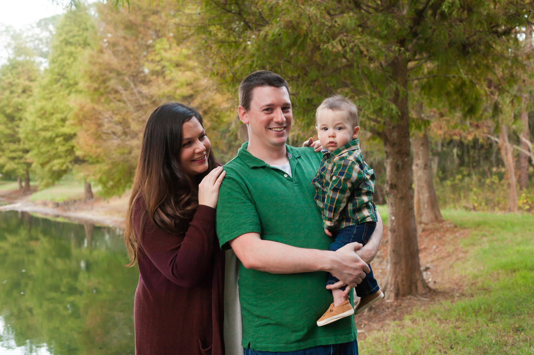 Family of three smiling in a park, Wesley Chapel