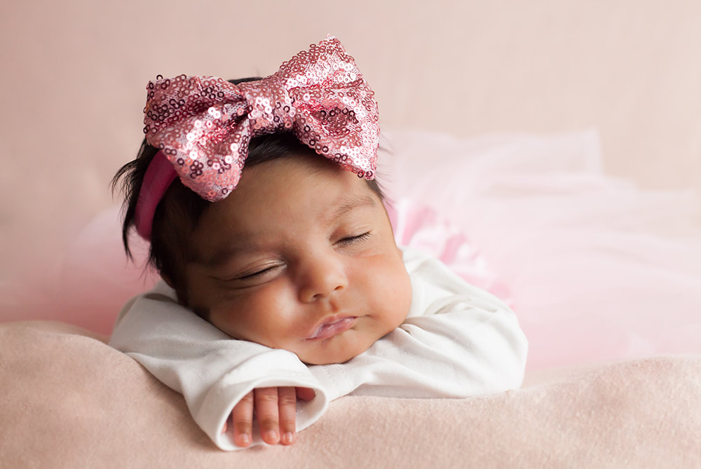 newborn baby girl in a tutu and sparkly headband lying on her tummy in Tampa, Fl