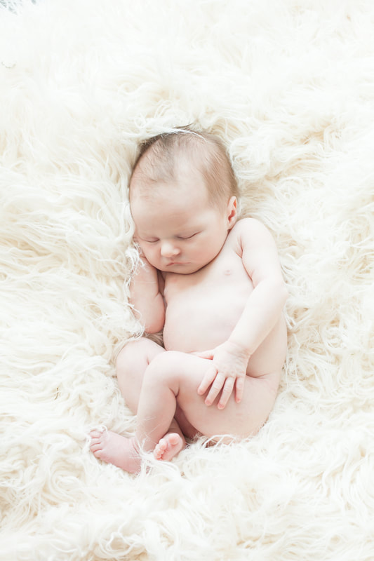 newborn baby sleeps peacefully on white fur