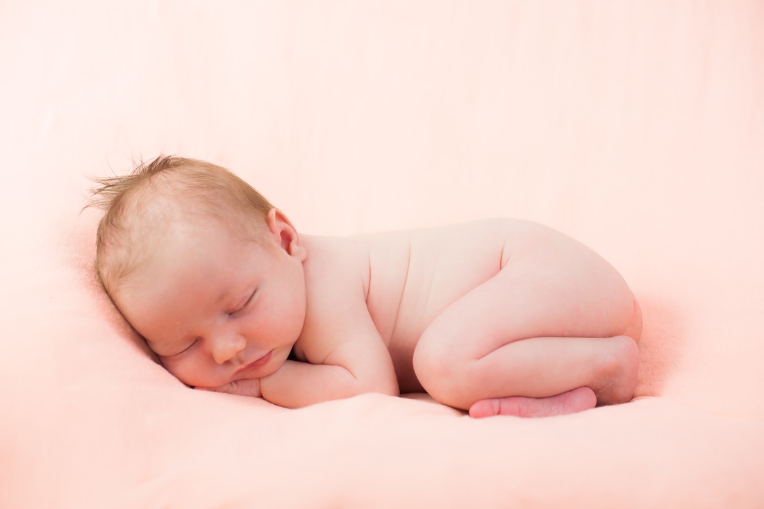 curled sleeping newborn baby pose in tampa