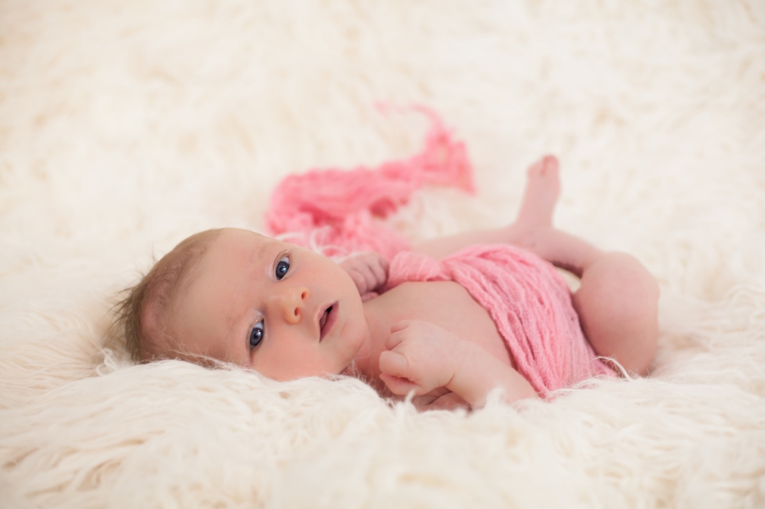 Newborn photo of baby looking into camera