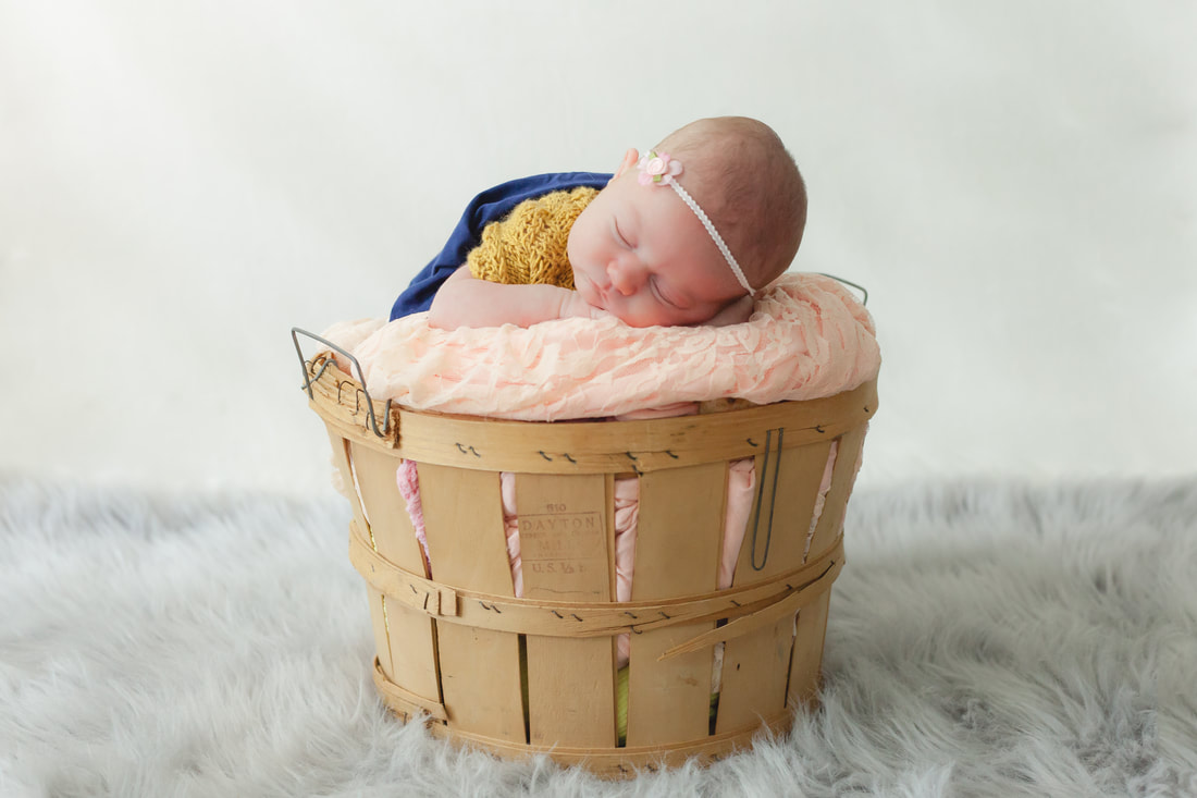 Baby girl sleeping peacefully in a basket 