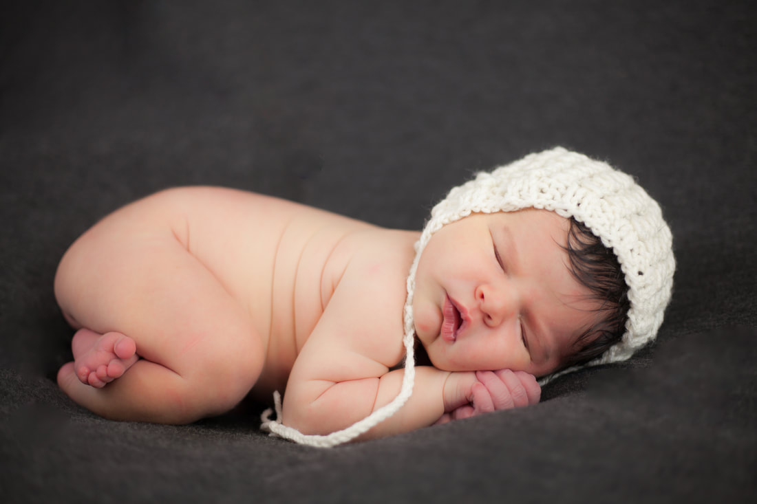 Newborn baby in white bonnet Photo in Tampa
