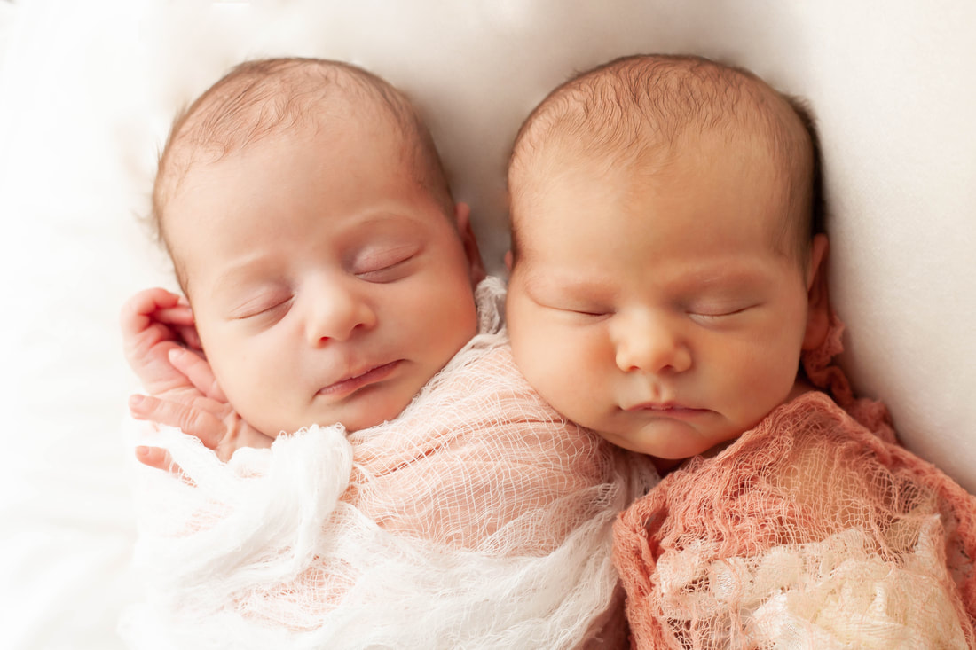 Close up of Twin baby girls snuggled close