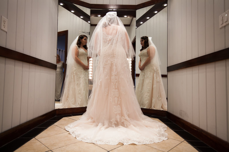 Tampa Bride admires her wedding dress in Mirror