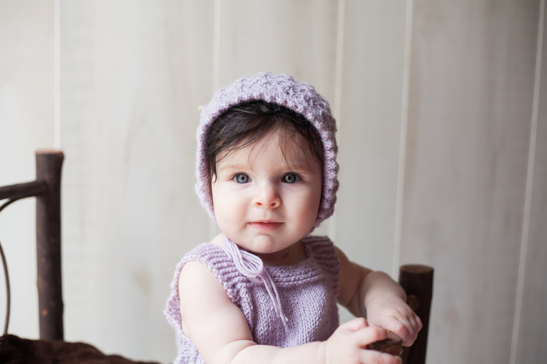 Serious six month old girl with bonnet