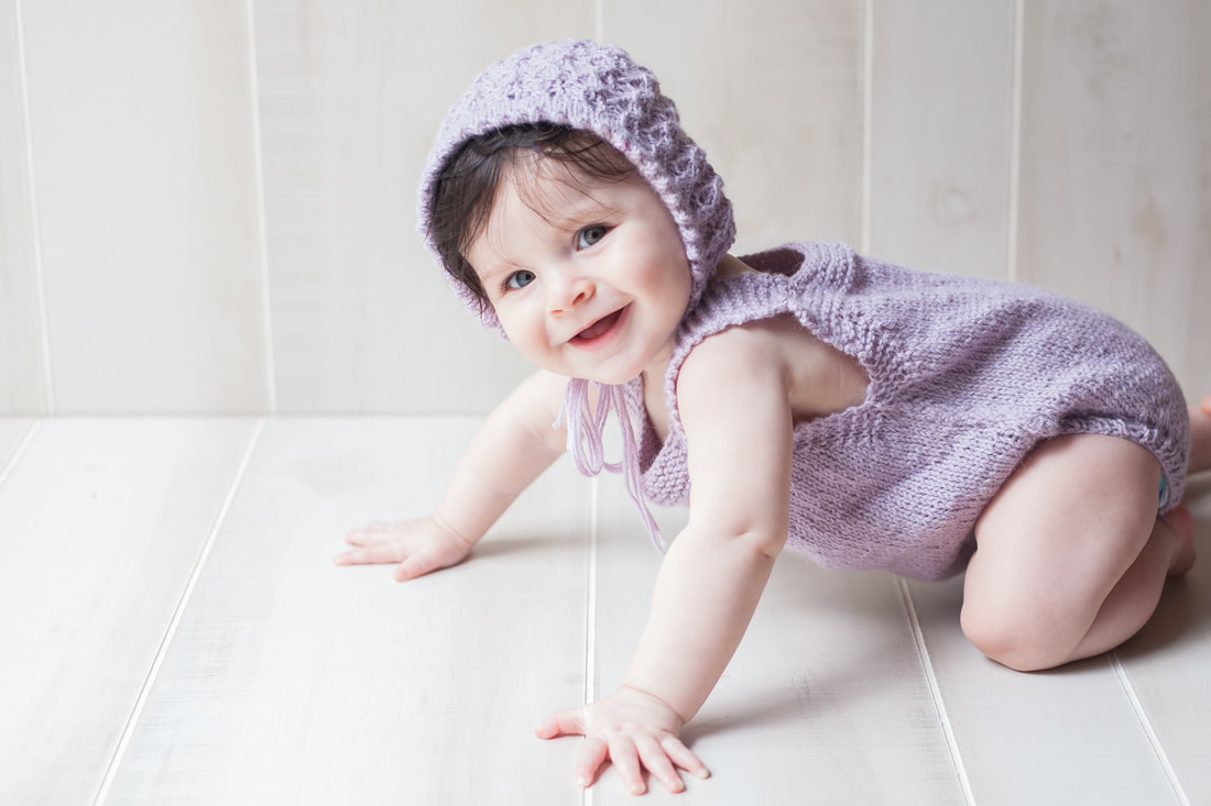Smiling baby girl in purple crawling