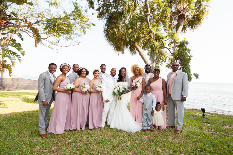 Entire bridal party poses by the edge of the water