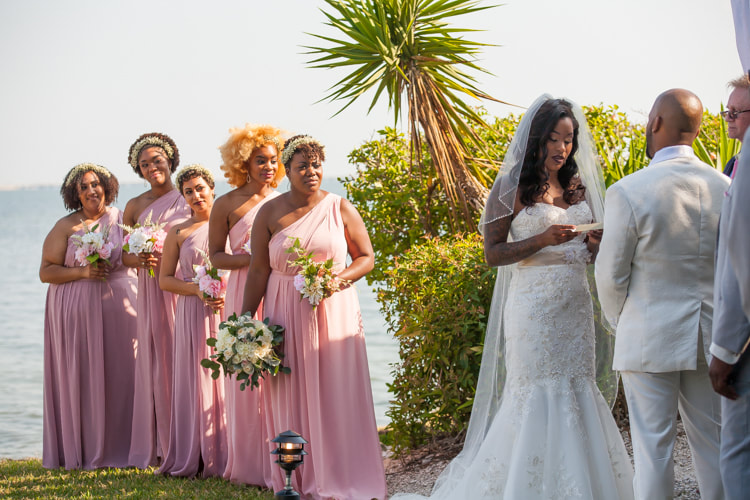 Bride reads her vows while bridesmaids look on