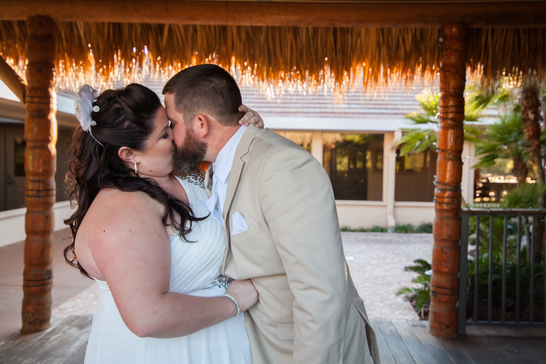 Bride and Groom kiss under tiki alter at the Citrus Hills Country Club