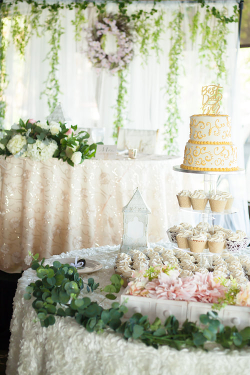 photograph of wedding cake with sweetheart table in the background at the rusty pelican