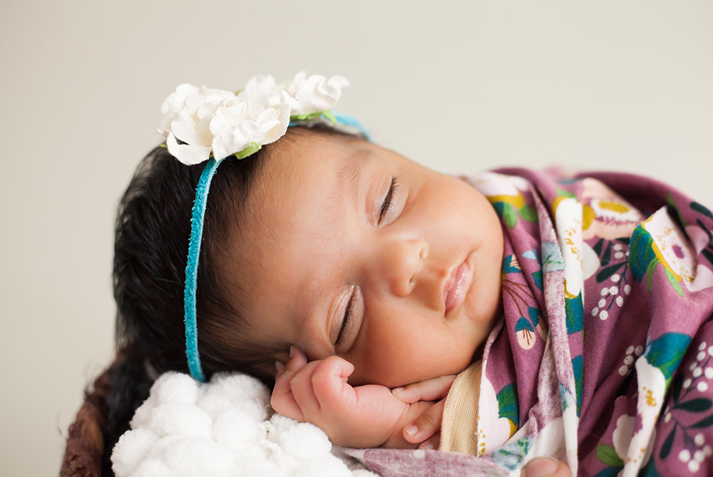 close up on newborn baby sleeping with hand under cheek