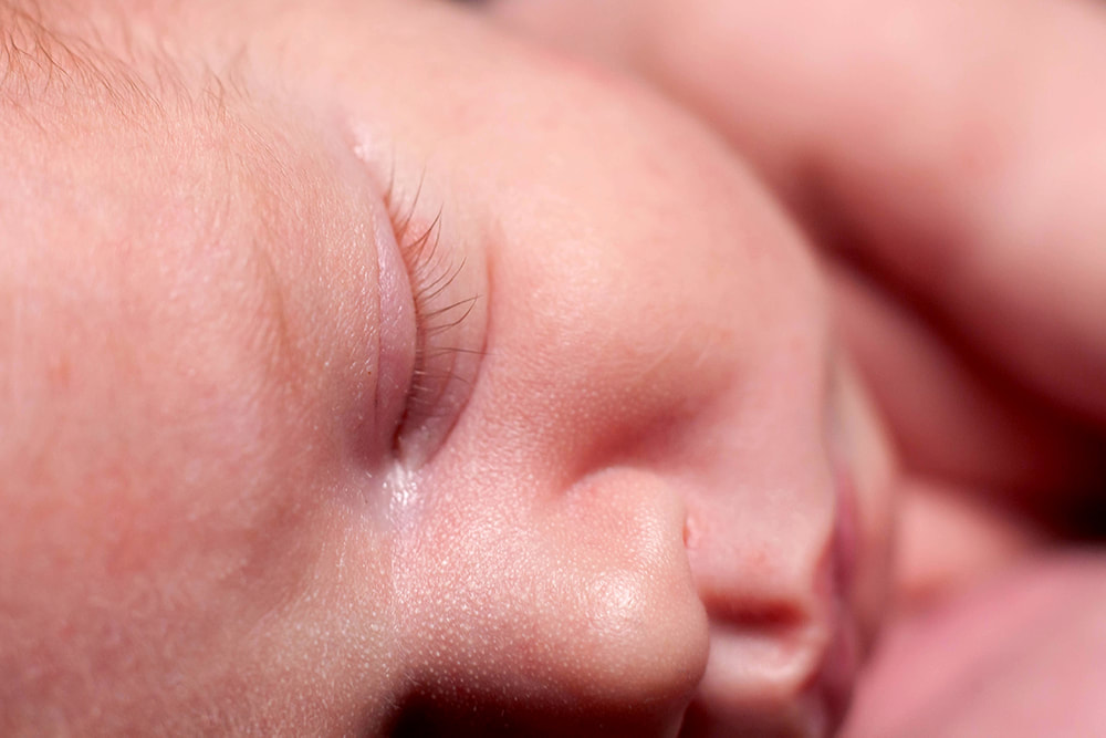 Extreme close up of sleeping newborn's face focused on baby's eyelashes