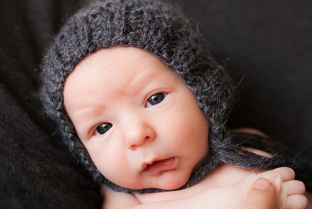 Close up photograph of newborn baby looking into the camera in Tampa Florida