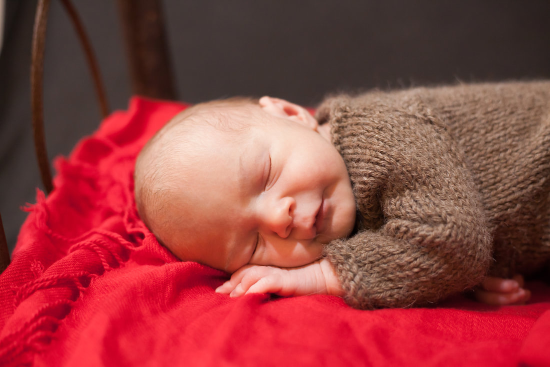 Sleeping baby lying on a wooden bed with a smiles