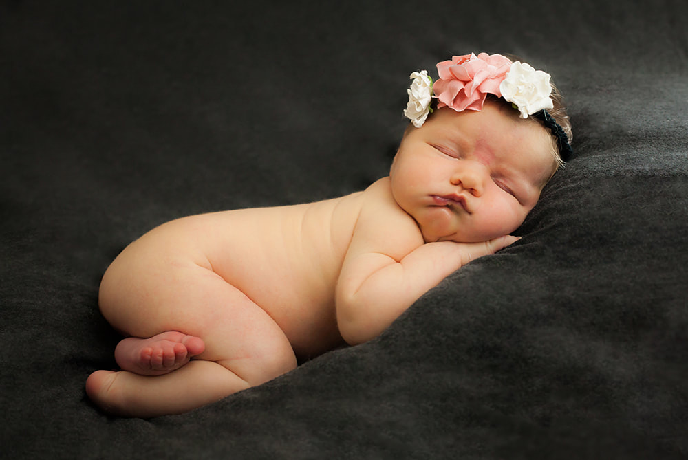 newborn baby girl sleeping with flower crown on
