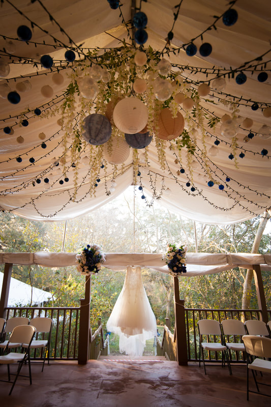 Wedding Gown hangs beneath decorated chandilier